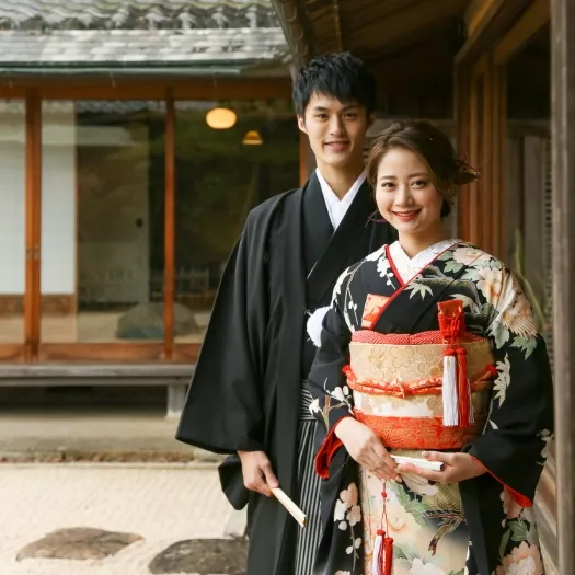 日本家屋を背にした紋付袴と色打掛のおふたり|伊勢おかげさま婚